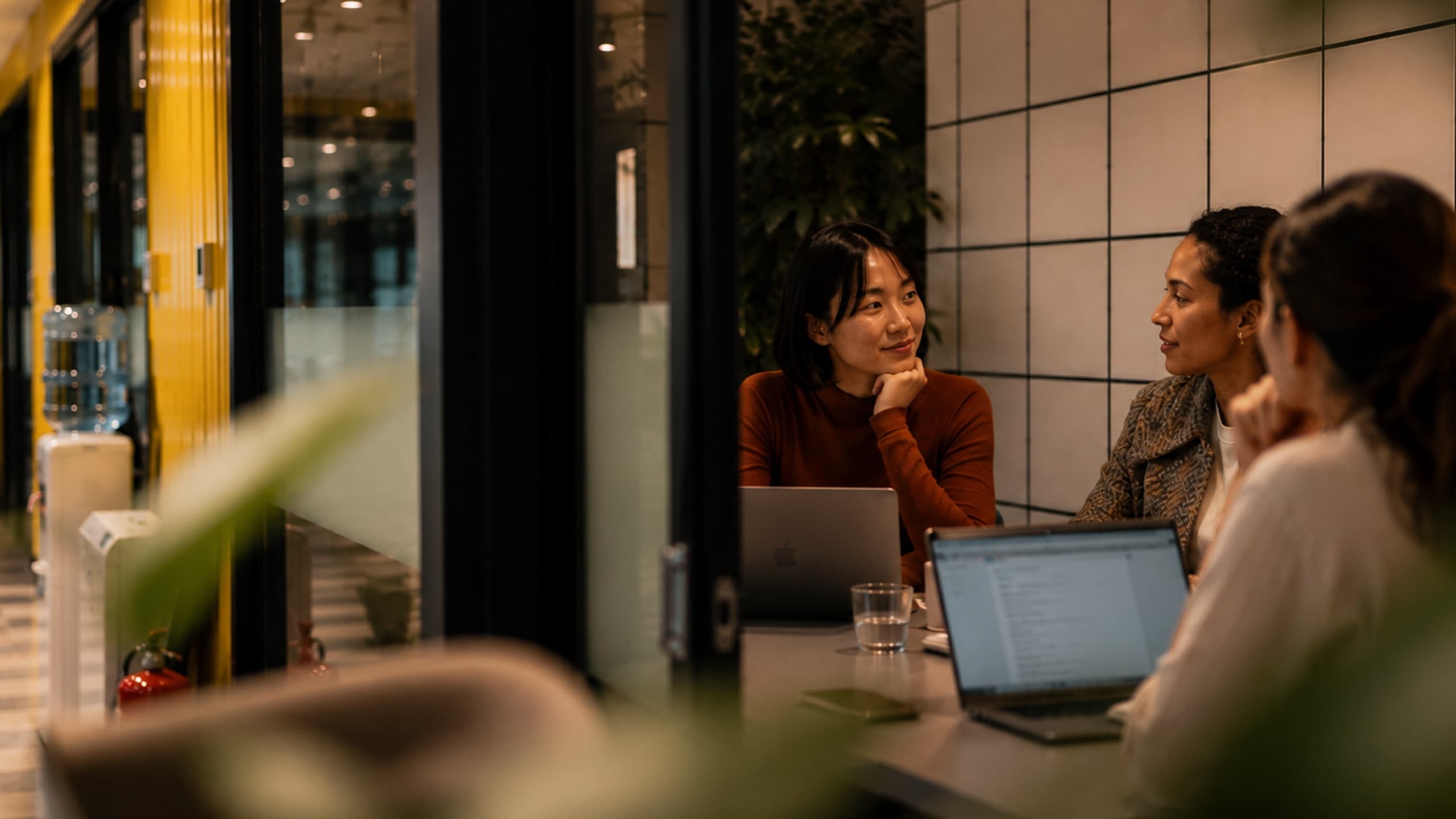 Members talking over laptops in a meeting room at tershouse