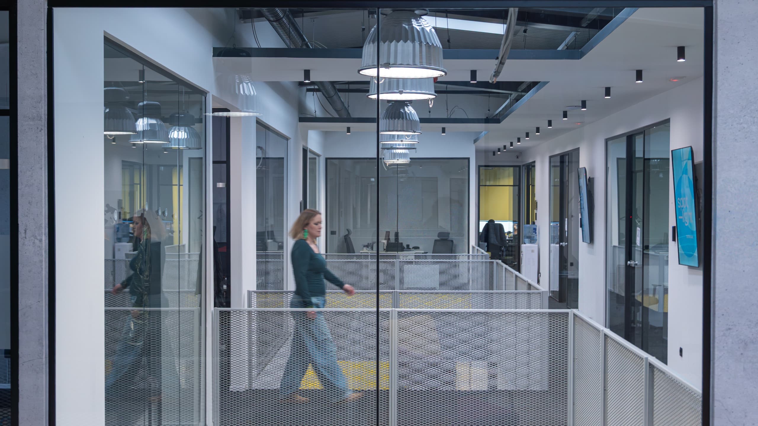A member walking past the glass meeting rooms on the tershouse gallery