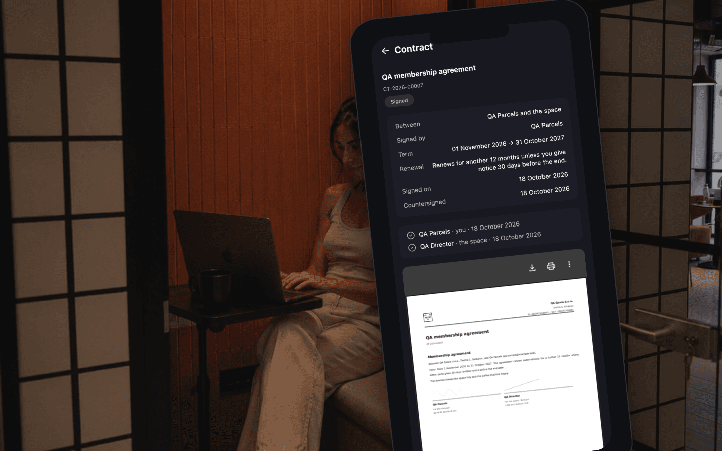 A phone in a booth showing a signed contract in the member app