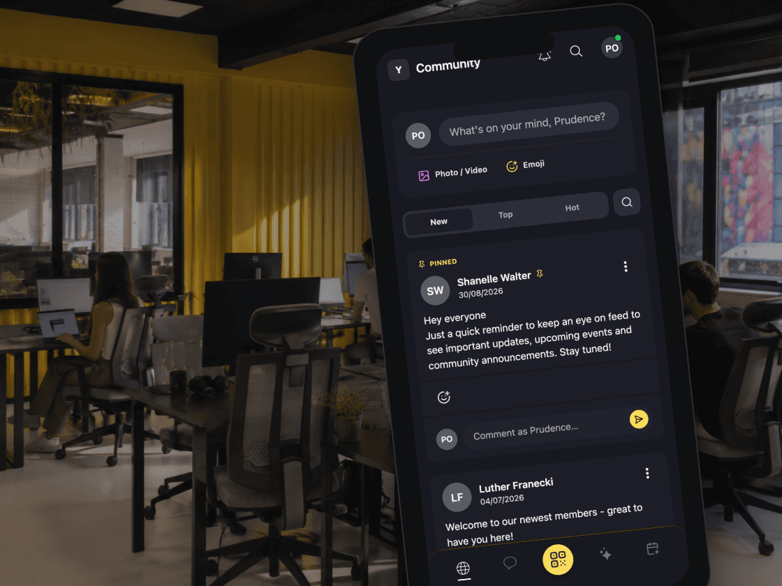 A phone at the desks showing the community feed in the member app